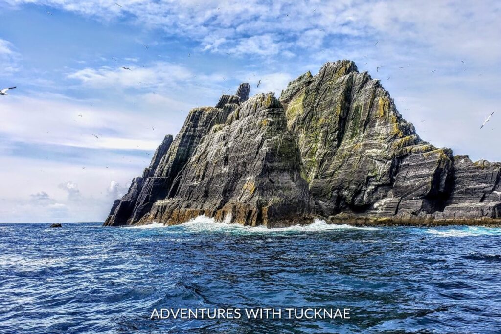 The ancient, jagged rock formations of Skellig Michael rise from the Atlantic, a breathtaking Instagram spot in Ireland frequented by seabirds under a cloudy sky.