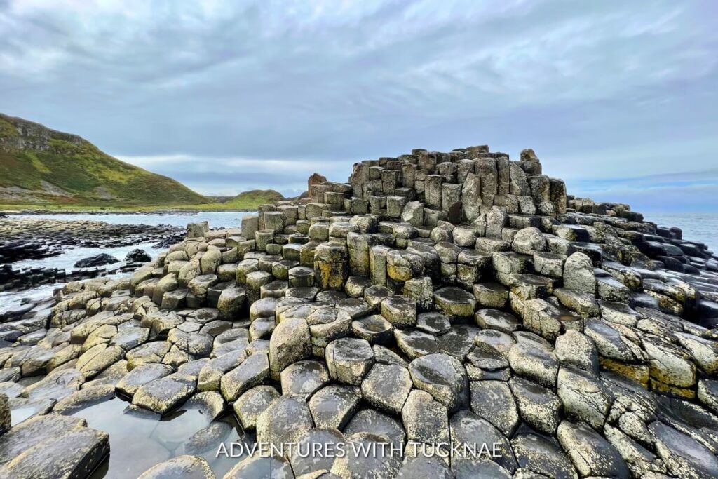 The iconic hexagonal basalt columns of the Giant’s Causeway under a cloudy sky, a geological wonder for weekend breaks in Ireland.
