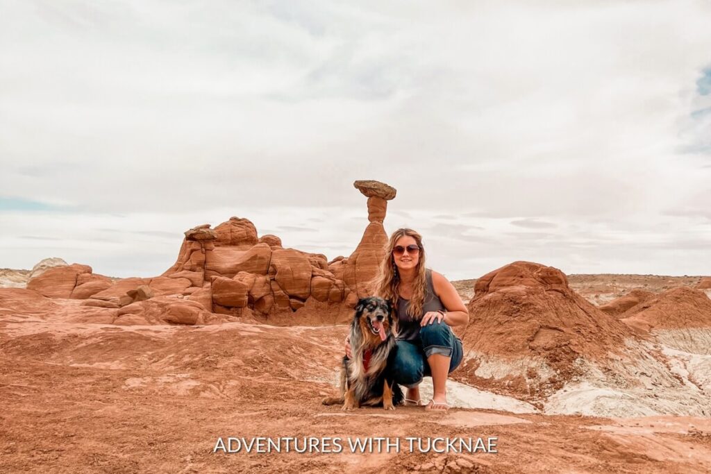 A girl posing with a dog beside the whimsical Toadstool Hoodoos, geological wonders along a hike near Kanab, Utah.