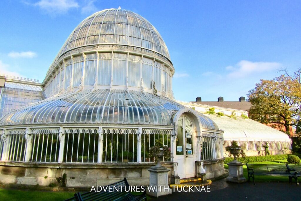 A striking view of the Palm House at Belfast Botanic Gardens, showcasing the intricate architecture and lush surroundings, making it one of the most Instagrammable places in Northern Ireland.