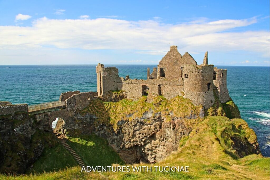 The historic ruins of Dunluce Castle perched on the edge of a cliff overlooking the North Atlantic Sea, an Instagrammable and evocative reminder of Northern Ireland's storied past.