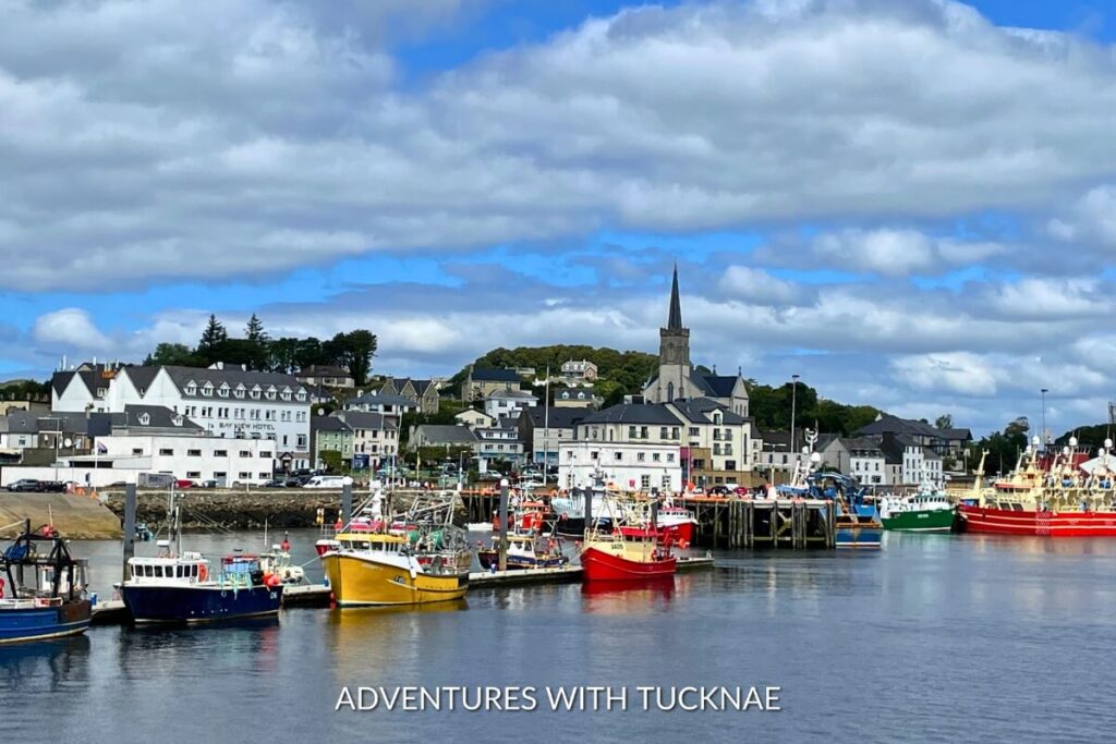 Killybegs harbor bustling with colorful fishing boats, flanked by the quaint town architecture, a picturesque and Instagrammable scene in Northern Ireland.