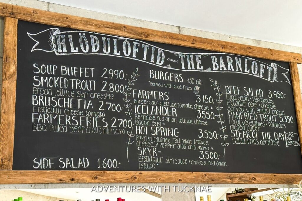 A chalkboard menu at a restaurant listing various dishes including smoked trout, bruschetta, burgers, and the soup buffet with prices in Icelandic króna.
