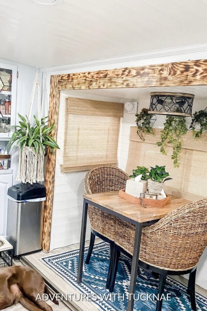 A BoHo style RV renovation dining room with wicker chairs and lots of plants