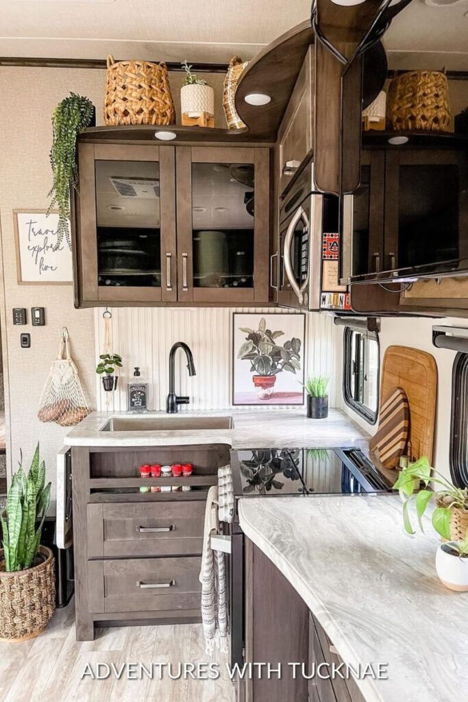 A simple RV kitchen renovation decorated with plants, decor, and a rug