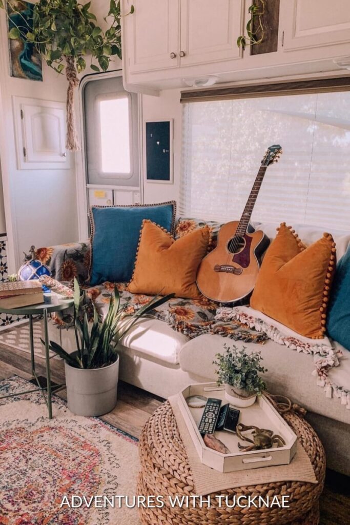 A BoHo style RV renovation with pillows and a guitar on the couch