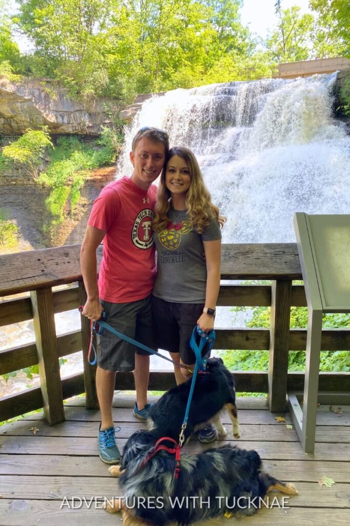 Tucker and Janae posing with Cap and Marvel in front of a cascading waterfall at Cuyahoga Valley National Park.