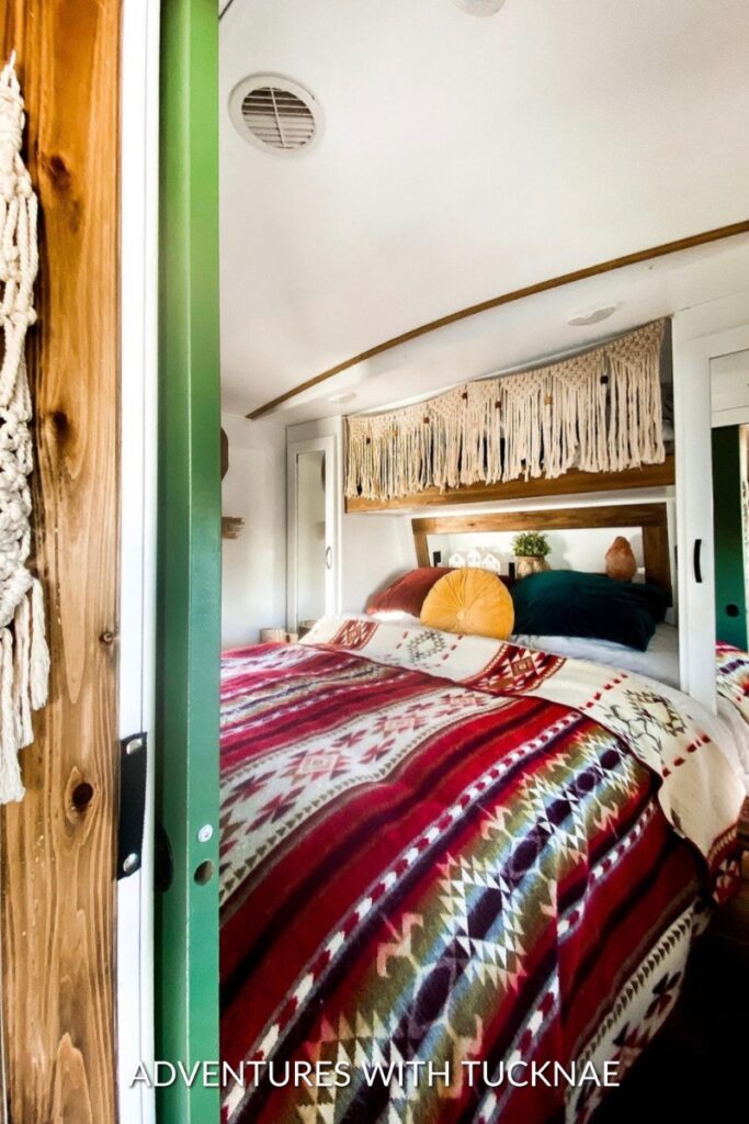Bohemian-style RV bedroom makeover with aztec bedding, macrame hangings, and decorative pillows